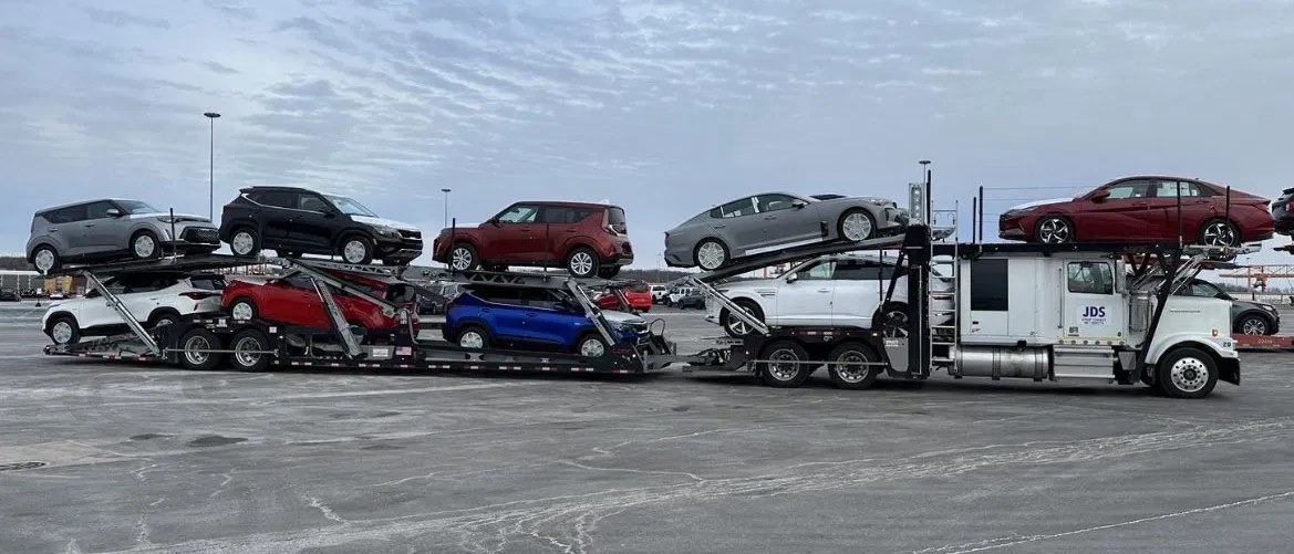 A loaded JDS open car carrier running an interstate lane