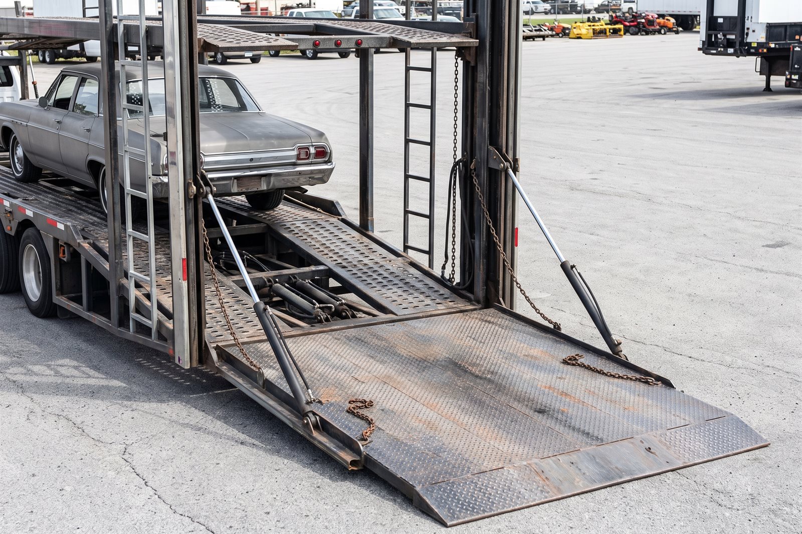 A car being driven up the loading ramp onto an open carrier deck